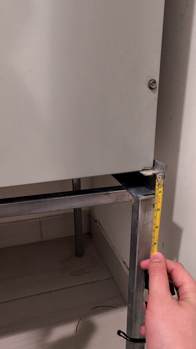 Measuring the thickness of the AC filter slot opening with a tape measure