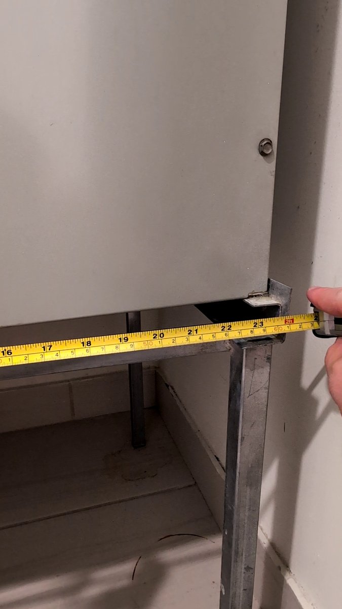 Measuring the width of the AC filter slot opening with a tape measure