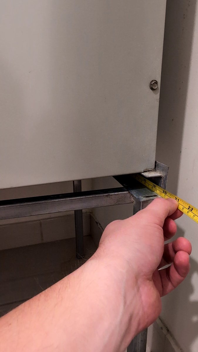 Measuring the length of the AC filter slot opening with a tape measure